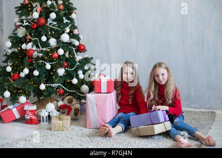 Deux petites filles blonde en robe rouge à cadeaux de noël vacances du Nouvel an Banque D'Images