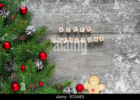 Joyeux Noël avec des branches de sapin inscription, décorations de fête et des pommes de pin sur table en bois rustique. Noël arrière-plan. Télévision lay. Vue de dessus Banque D'Images