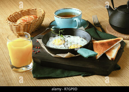 Les œufs frits dans une poêle pour le petit-déjeuner avec du pain Banque D'Images