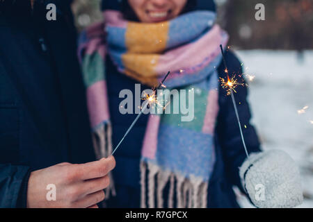 Beau couple aimant cierges brûlant dans la forêt d'hiver. Noël et Nouvel an concept. Close up Banque D'Images