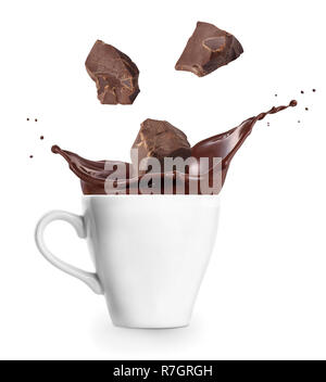 Éclaboussures de chocolat chaud avec des pièces qui tombent dans la tasse isolé sur fond blanc Banque D'Images