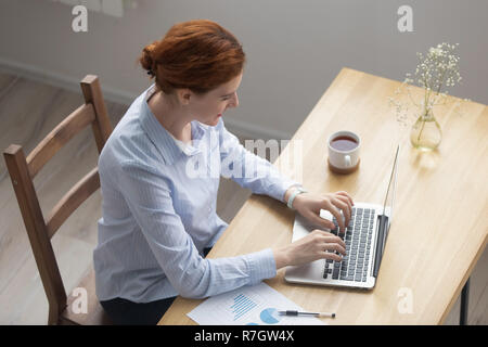 Haut au-dessus de la jeune femme travaillant sur ordinateur Banque D'Images