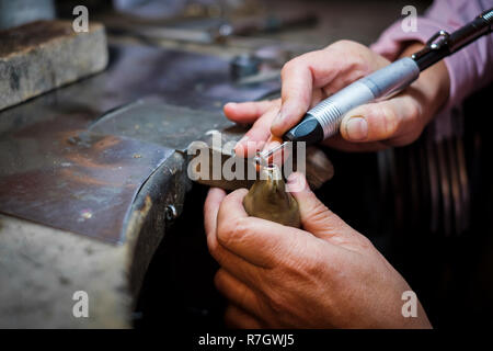 Bijoutier polit une bague en or sur un vieux workbench dans un authentique atelier de joaillerie Banque D'Images