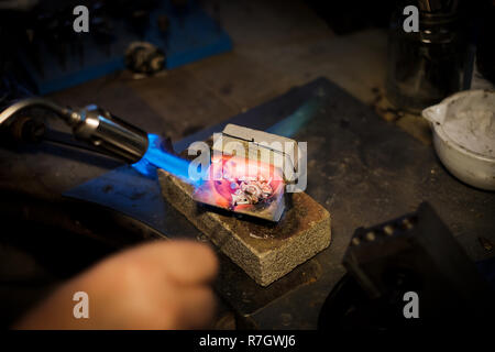 Fond Bijoutier avec une flamme d'argent, d'or sur l'ancien poste de travail en atelier de bijoutier Banque D'Images