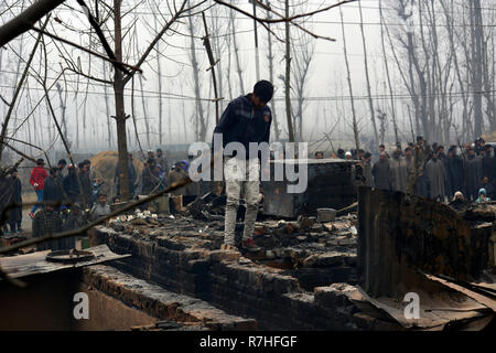 Srinagar, Jammu-et-Cachemire, en Inde. 9Th Mar, 2018. Cachemiris inspecter les maisons ravagé par la guerre où les militants ont été retranchés lors de coups de feu avec les forces du gouvernement indien dans la zone Mujgund de Srinagar, la capitale d'été du Cachemire indien, l'Inde. Garçon de 14 ans a été parmi les trois militants tués dans la fusillade. Six maisons ont aussi été endommagées. Credit : Masrat Zahra/ZUMA/Alamy Fil Live News Banque D'Images