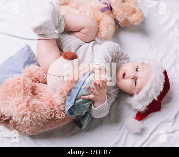 Happy Baby in Santa's hat avec des jouets mous Banque D'Images