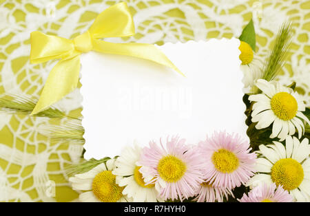 Bouquet de marguerites blanches et roses avec une carte sur fond de crochet Banque D'Images