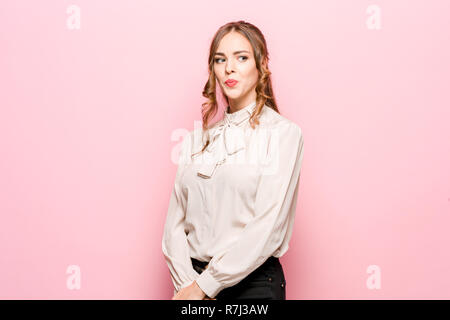 Permettez-moi de penser. Doute concept. Femme pensive douteux avec air pensif faire des choix. Jeune femme émotionnelle. Les émotions humaines, l'expression faciale concept. Studio. Isolé sur rose à la mode Banque D'Images