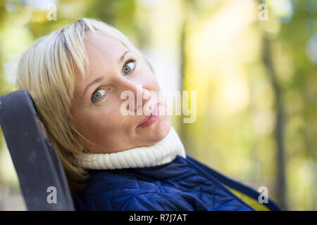 Quarante ans, femme ordinaire sur un banc de parc Banque D'Images
