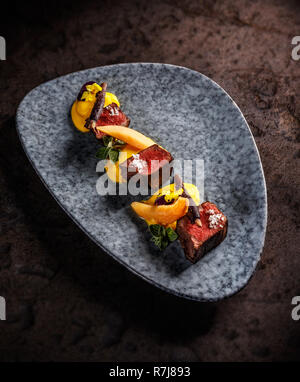 Filet de chevreuil avec purée de patate douce, carotte pourpre blanchies, confiture de coing avec du vin Banque D'Images