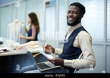 Créateur de mode afro-américain excité en studio Banque D'Images