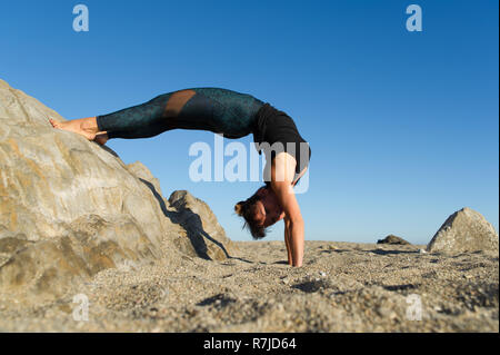 Argelès-sur-Mer (sud-est de la France). Des exercices d'étirement après la pratique du yoga sur les rochers en face de la plage Racou tôt le matin Banque D'Images