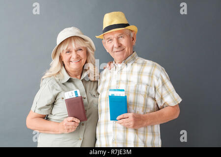 Touristes studio isolés sur gris de nationalités et de billets à heureux de l'appareil photo Banque D'Images