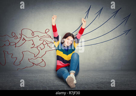 La jeune femme gaie excité hands up assis sur le plancher professionnels émotion concept de traitement de l'information comme les lignes de maillage venir par tête et Banque D'Images