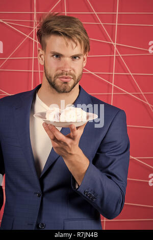 Maintenir la plaque homme avec zephyr, dessert. Man in suit avec de la guimauve, de l'alimentation. Dessert, confiserie, biscuits, sweet shop. Régime alimentaire, menu de cuisine recettes plats snack Banque D'Images