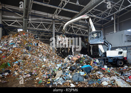 Minsk, Belarus - Octobre 2018 : processus de téléchargement de l'usine de recyclage de déchets convoyeur . Avec manipulateur grabber télécharge déchets sur convoyeur pour la furt Banque D'Images