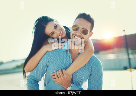 Happy young couple smiling tendance à poser de ferroutage oudoors Banque D'Images