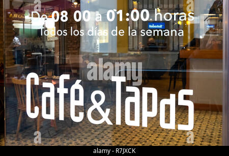 Affiches de fenêtre indiquant les heures et Cafe & Tapas dans un bar-café à Séville, Espagne Banque D'Images