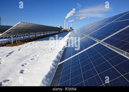 Alternative Energy - marque de nouveaux panneaux solaires. Centrale thermique à l'arrière-plan. Ciel bleu réfléchissant sur les panneaux. Banque D'Images