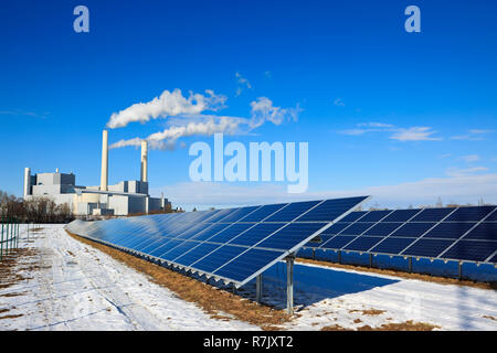 Alternative Energy - marque de nouveaux panneaux solaires. Centrale thermique à l'arrière-plan. Ciel bleu réfléchissant sur les panneaux. Banque D'Images