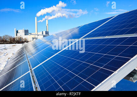 Alternative Energy - marque de nouveaux panneaux solaires. Centrale thermique à l'arrière-plan. Ciel bleu réfléchissant sur les panneaux. Banque D'Images