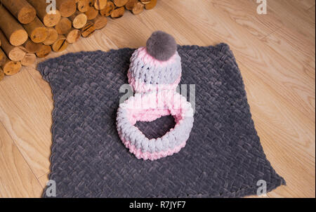 À côté de la cheminée est un chapeau et un foulard très délicate sur un plaid gris. Séance photo en studio. Banque D'Images