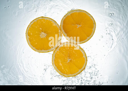 Les oranges, les éclaboussures d'eau sur fond blanc Banque D'Images