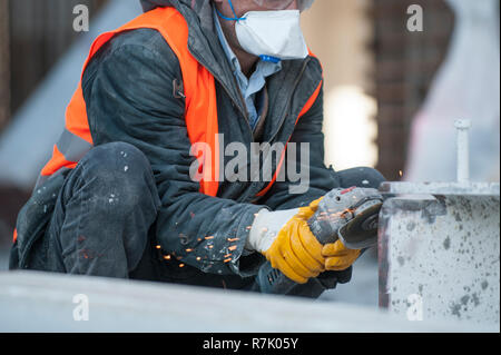 Worker cutting metal avec grinder at construction site.tandis que le broyage de Sparks Banque D'Images