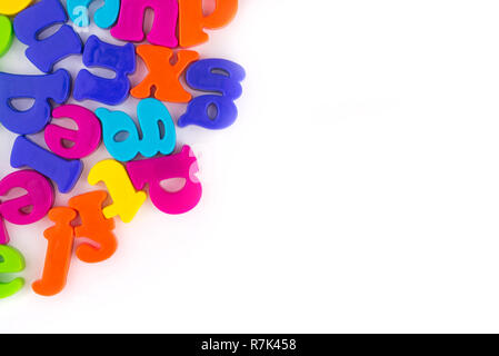 Lettres en plastique colorés isolé sur blanc.Concept de l'éducation, l'enseignement en ligne et à la maison.Pour un texte. Banque D'Images