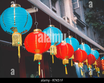 Lanternes de papier chinois sur l'oscillation de vent sur le toit d'un bâtiment par jour dans la rue Banque D'Images