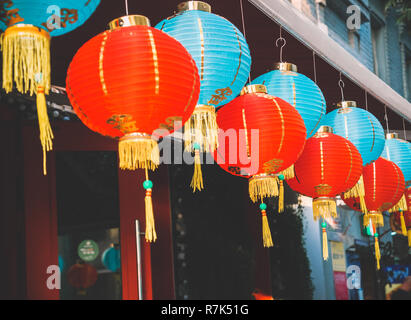 Lanternes de papier chinois sur l'oscillation de vent sur le toit d'un bâtiment par jour dans la rue Banque D'Images