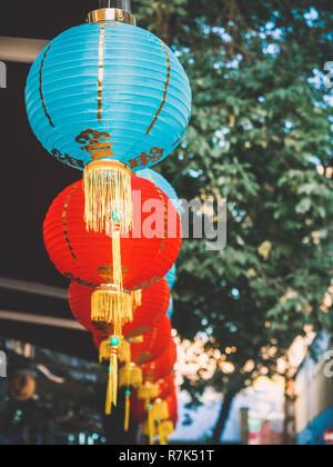 Lanternes de papier chinois sur l'oscillation de vent sur le toit d'un bâtiment par jour dans la rue Banque D'Images