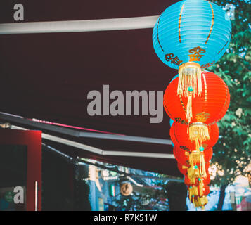 Lanternes de papier chinois sur l'oscillation de vent sur le toit d'un bâtiment par jour dans la rue Banque D'Images