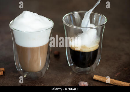 Mousse de lait est mis dans un verre de café. Banque D'Images
