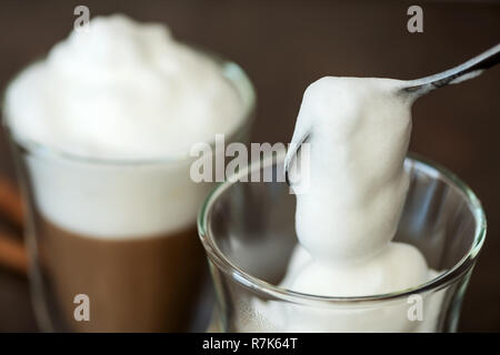 Mousse de lait est mis dans un verre de café. Banque D'Images