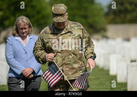 Chef de l'armée américaine, le général Mark Milley et sa femme Hollyanne met les drapeaux sur les tombes de soldats tombés pendant le jour du Souvenir au Cimetière National d'Arlington, le 26 mai 2016 à Arlington, en Virginie. Milley a été choisi par le Président Donald Trump le 8 décembre 2018 pour être le prochain chef d'état-major interarmées. Banque D'Images