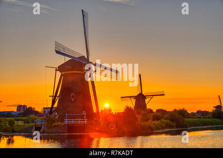 Avis de moulins à vent traditionnels au coucher du soleil à Kinderdijk, aux Pays-Bas. Ce système de 19 moulins à vent a été construit autour de 1740 et est un patrimoine de l'UNESCO s'asseoir Banque D'Images