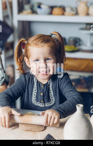 Peu de professionnels le gingembre girl with rolling-pin le travail de l'argile dans le craft studio Banque D'Images