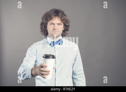 Close up portrait of happy bel homme en chemise bleue avec du papier tasse de café du matin. Bon matin avec du thé. Café à emporter, le temps d'une pause-café. Waiter propose du café à emporter. Tonique. Copier l'espace. Banque D'Images