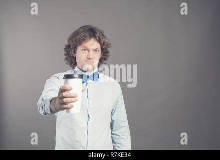 Close up portrait of happy bel homme en chemise bleue avec du papier tasse de café du matin. Bon matin avec du thé. Café à emporter, le temps d'une pause-café. Garçon de café propose d'aller. Tonique. Copier l'espace. Banque D'Images