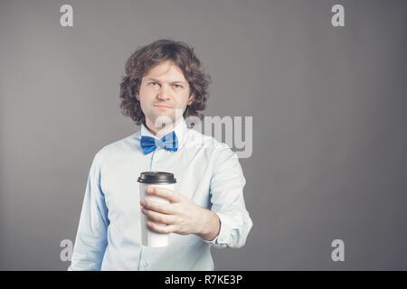 Portrait of happy bel homme en chemise bleue et cravate d'arc avec tasse de papier de café du matin. Bon matin avec du thé. Café à emporter, le temps d'une pause-café. Garçon de café propose d'aller. Tonique. Copy space Banque D'Images