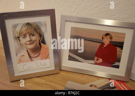 30 novembre 2018, en Rhénanie du Nord-Westphalie, Attendorn : une photo d'Ursula Wanecki (r), Merkel, Double est debout dans son appartement à côté d'une carte autographe du chancelier fédéral (l) sur son bureau. Photo : Oliver Berg/dpa Banque D'Images