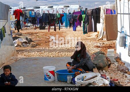 Baalbek, au Liban. Dec 10, 2018. Une femme syrienne se lave les vêtements à un camp de réfugiés près de la ville de Baalbek au Liban de l'est de la Bekaa, le 10 décembre 2018. Les réfugiés syriens dans le camp sera un autre hiver ici. Credit : Bilal Jawich/Xinhua/Alamy Live News Banque D'Images