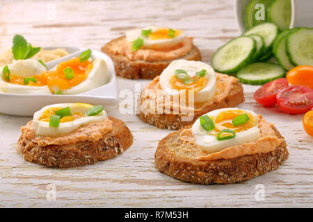 Sandwiches avec de la pâte de saumon et oeuf sur le fond en bois blanc Banque D'Images