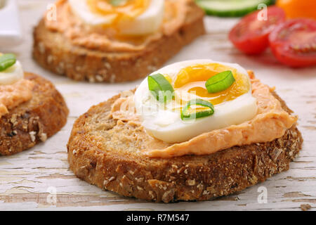 Sandwiches avec de la pâte de saumon et oeuf sur le fond en bois blanc Banque D'Images