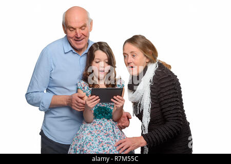 Petite-fille et les grands-parents à l'aide de tablet Banque D'Images