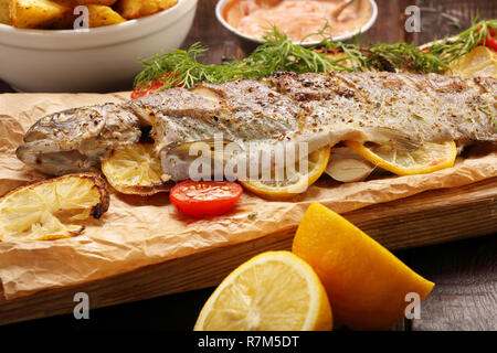 Du poisson cuit au four avec pommes de terre rôties et trempette Banque D'Images