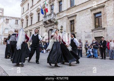 Italie, Sardaigne, dans l'ouest de la Sardaigne, Alghero, Carrer de la Merce, troupe folklorique autochtone place Piazza del Comune en face du palais Palazzo Ducale s'asseoir de l'hôtel de ville Banque D'Images