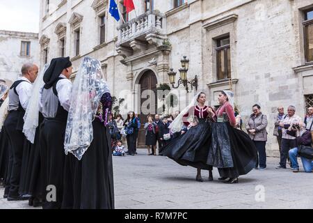 Italie, Sardaigne, dans l'ouest de la Sardaigne, Alghero, Carrer de la Merce, troupe folklorique autochtone place Piazza del Comune en face du palais Palazzo Ducale s'asseoir de l'hôtel de ville Banque D'Images