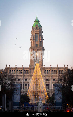 Shot verticale de l'arbre de Noël à l'Avenida dos Aliados, à Porto, au Portugal, en face de la Camara do Porto, au crépuscule. Fond de ciel clair avec se Banque D'Images